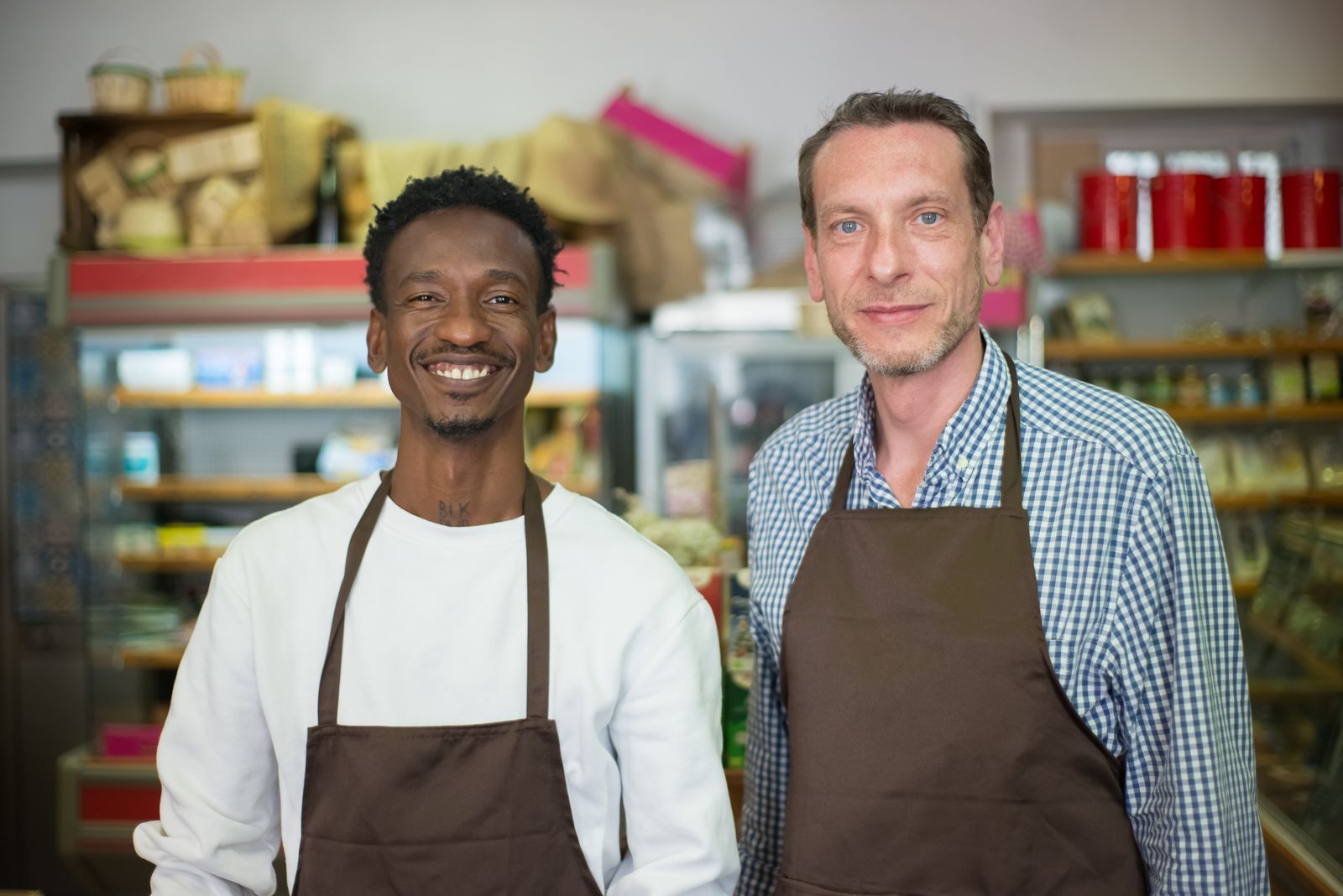 Two small-business owners standing together inside their shop