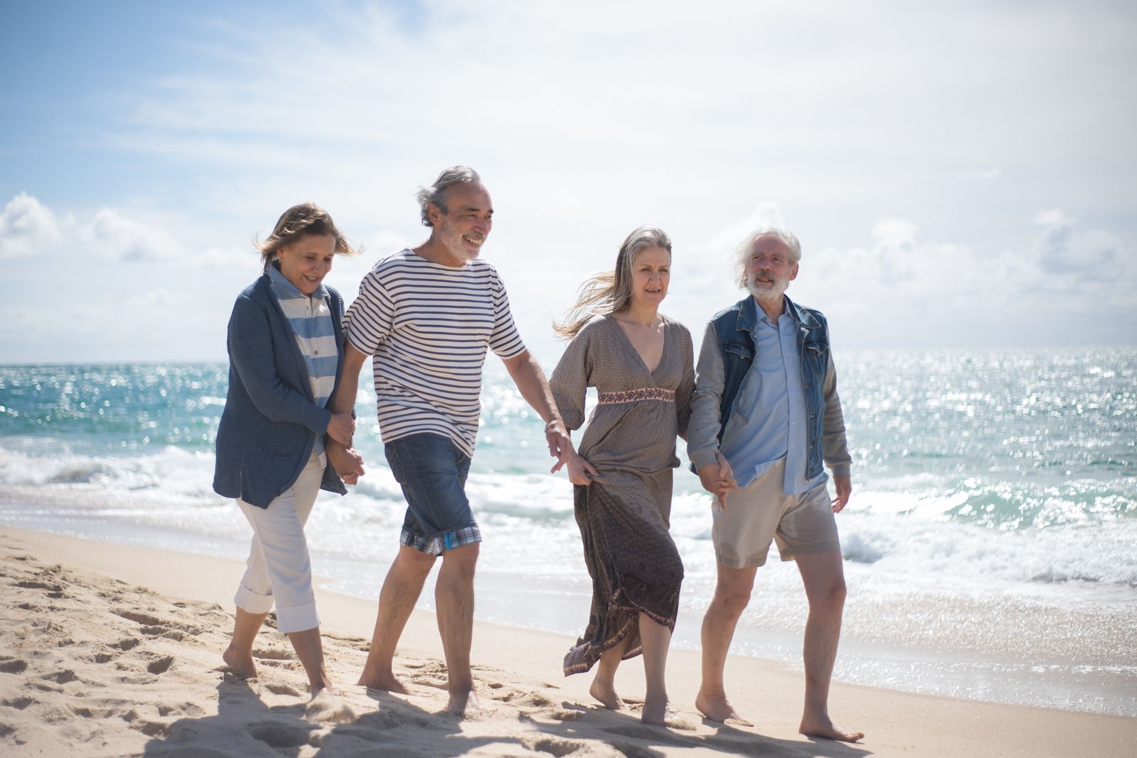 An older couple walking together along a beach in retirement