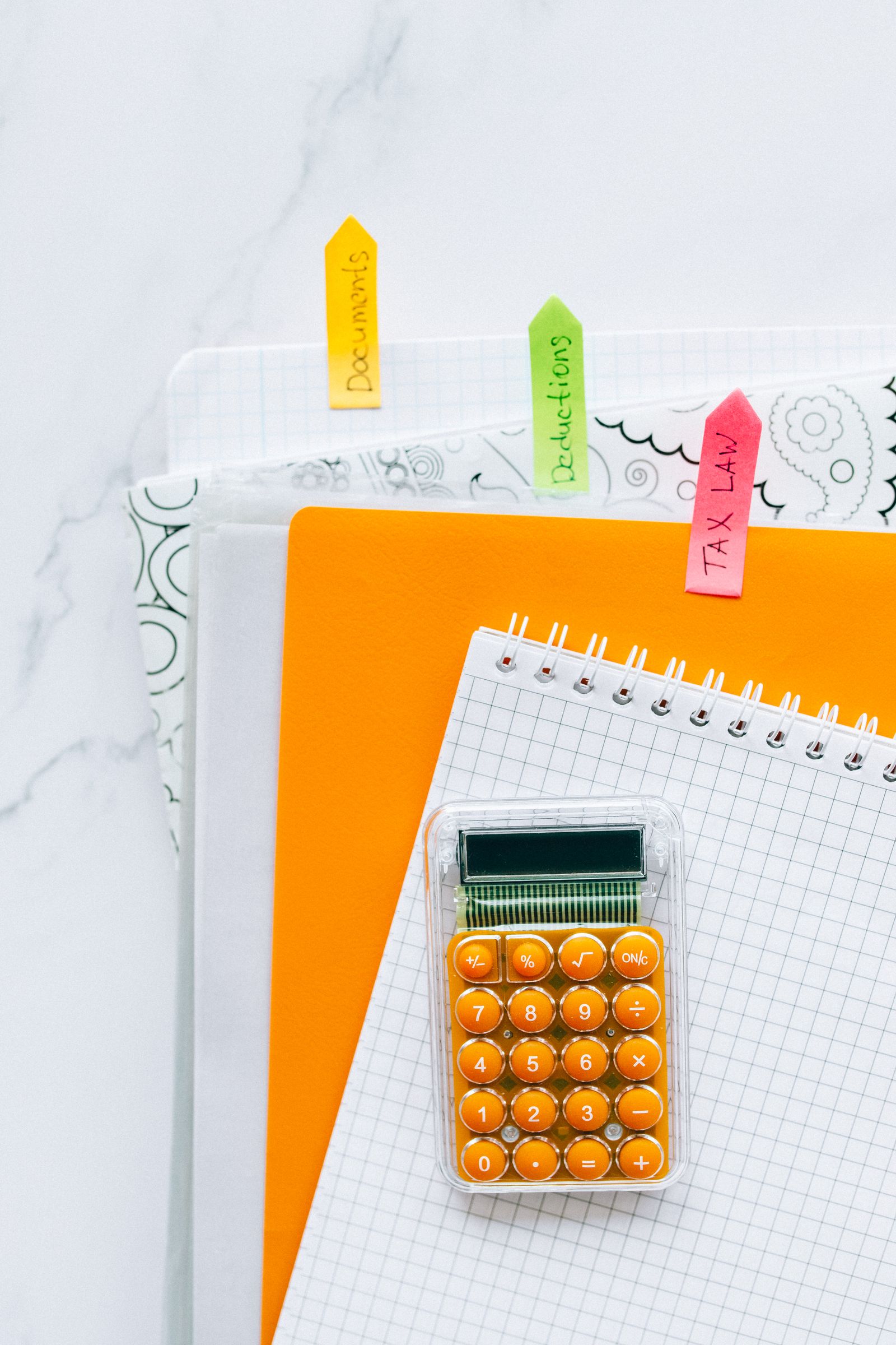 A calculator beside tax documents and labelled deduction notes